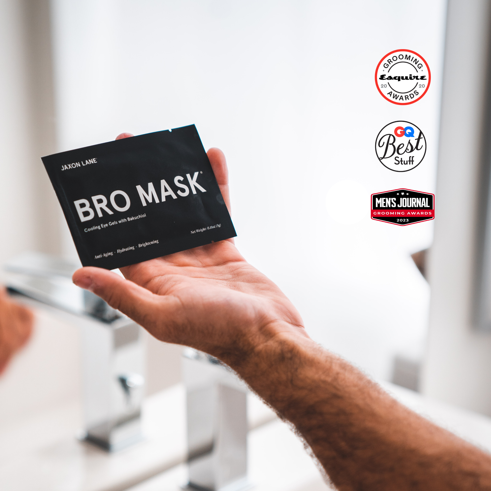 Hand holding a 'BRO MASK' package with awards logos on a blurred background