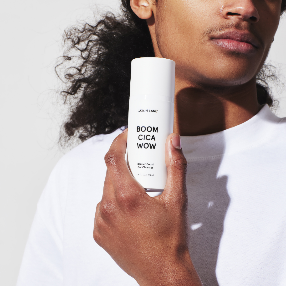 Man smiles while applying foaming cleanser to his face 