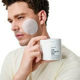 Product View 2 Man applying 'The Glow Up Pad' to his face with a jar of the product in hand.