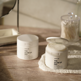 Product View 8 Two jars labeled 'The Glow Up Pad' on a wooden surface with a blurred background.