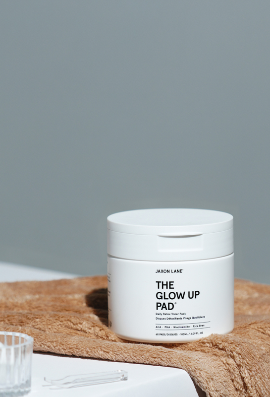 Jar of 'The Glow Up Pad' by JASON LANE on a textured surface with a gray background